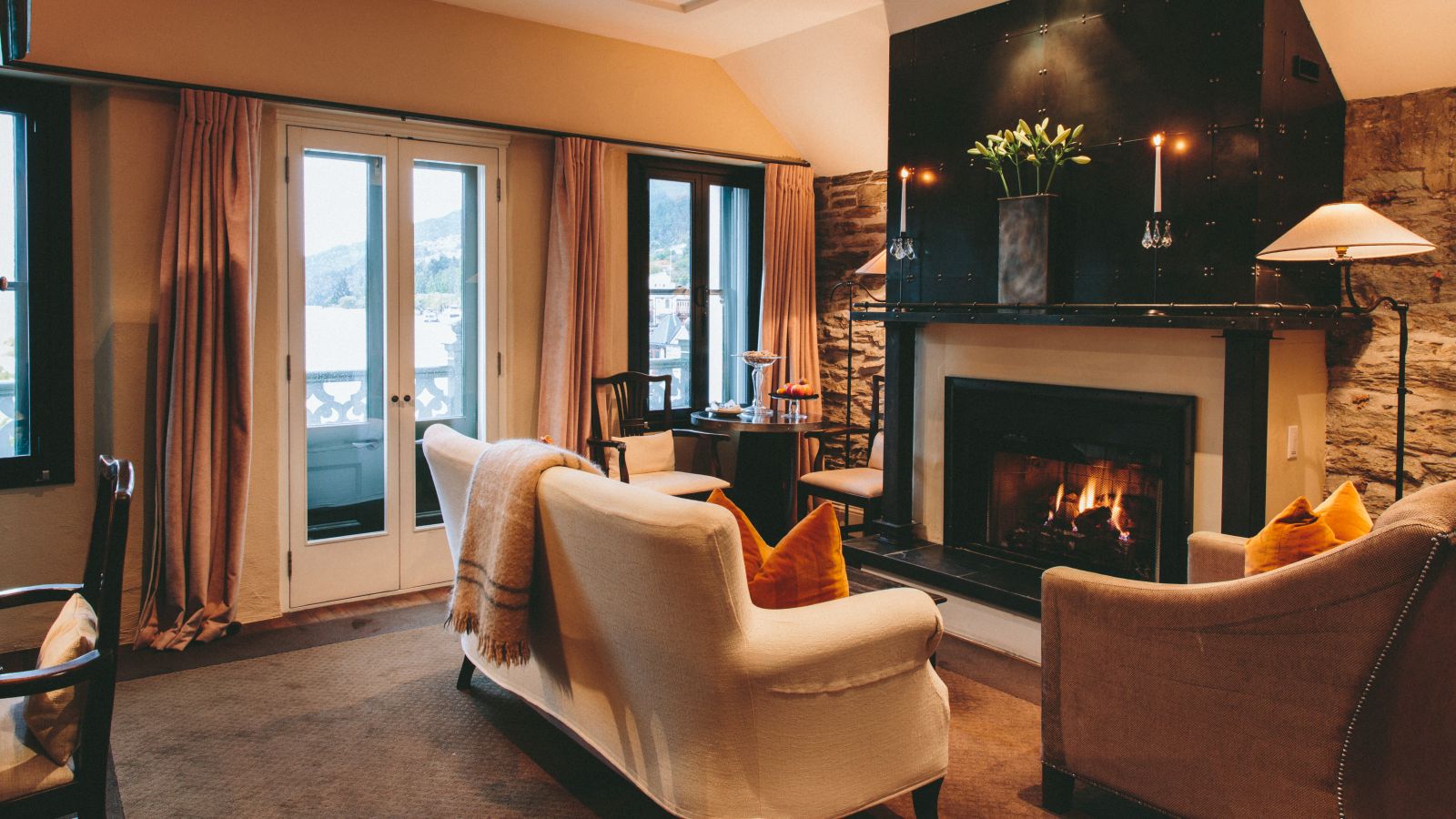 Eichardt's Private Hotel New Zealand suite with a glowing fire in the fireplace and a sofa