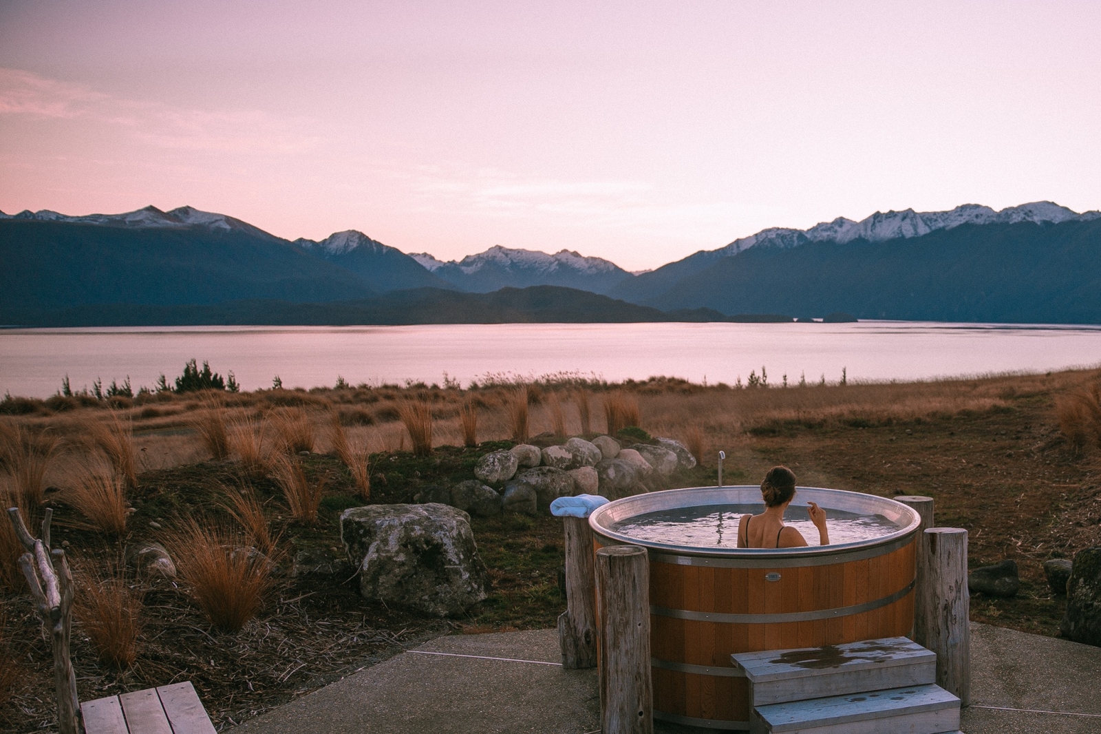 Man sitting in a hottub with view of the fiord