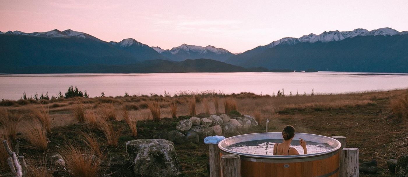 Man sitting in a hottub with view of the fiord