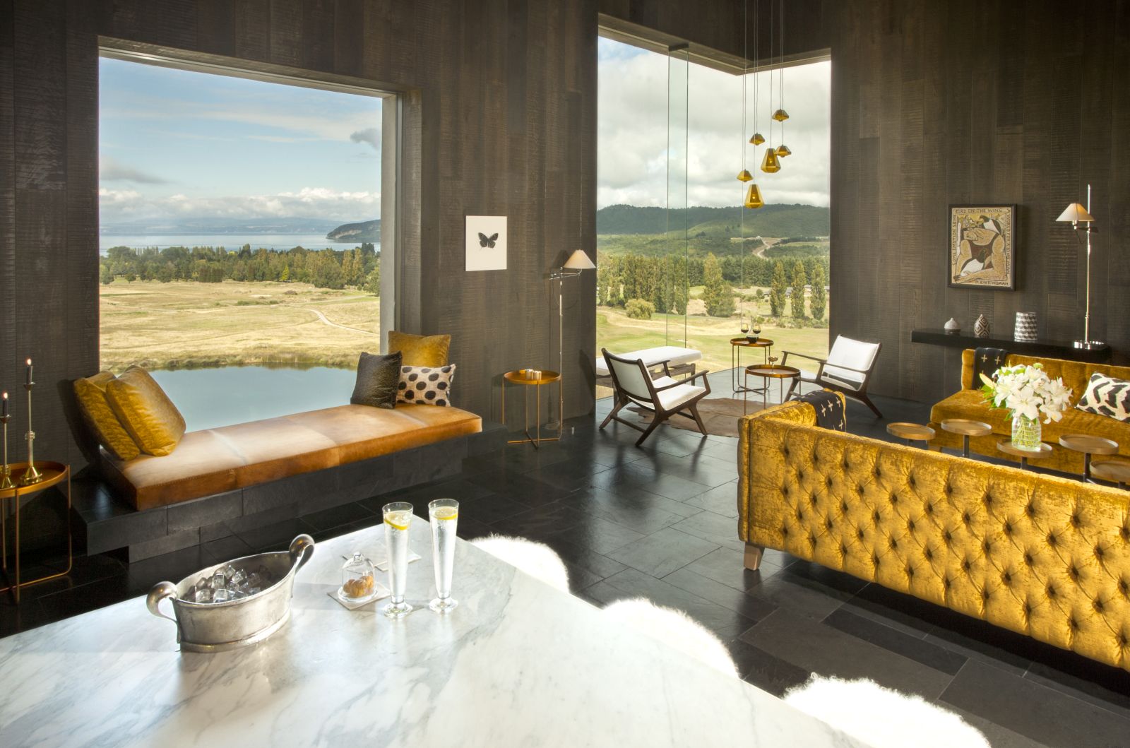 Kinloch Club New Zealand lounge area with yellow sofas and two drinks