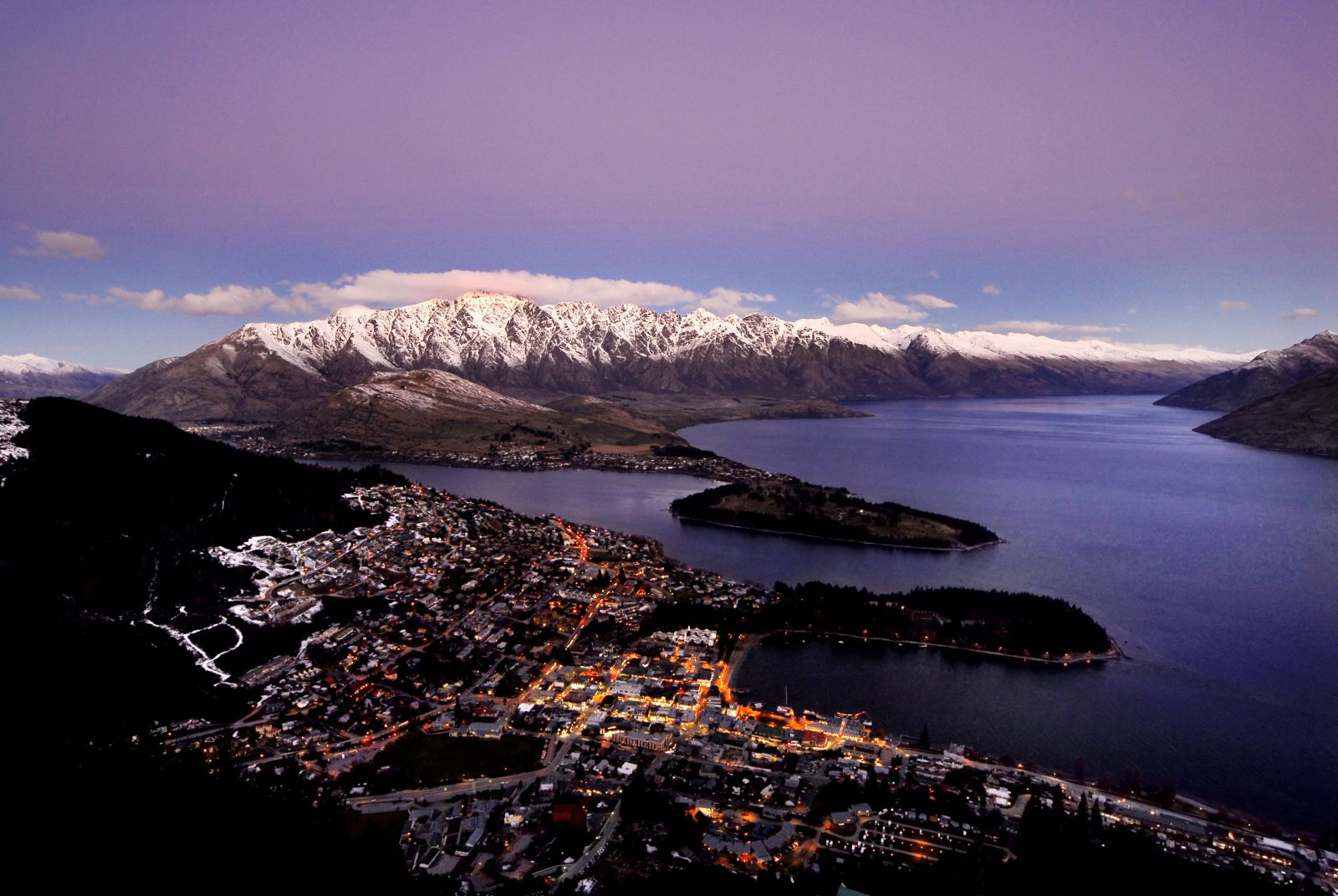 Mountain view of Queentown at dusk with snowy mountains in the background