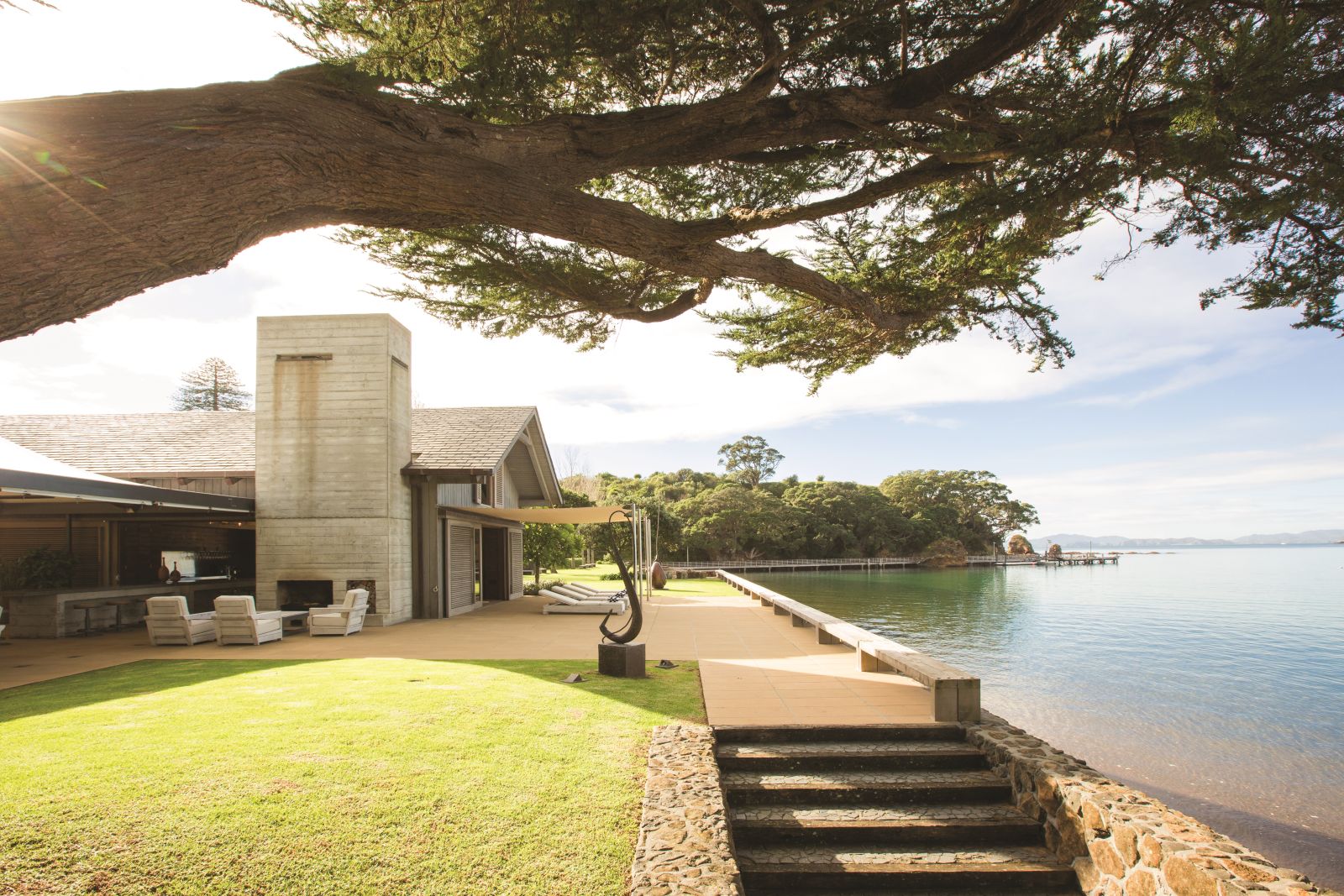 The Landing New Zealand The Boathouse exterior with outside seating overlooking the shore