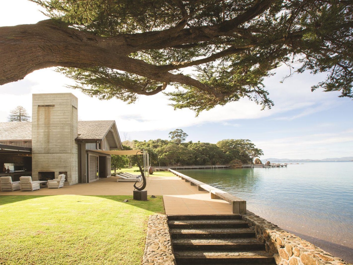 The Landing New Zealand The Boathouse exterior with outside seating overlooking the shore