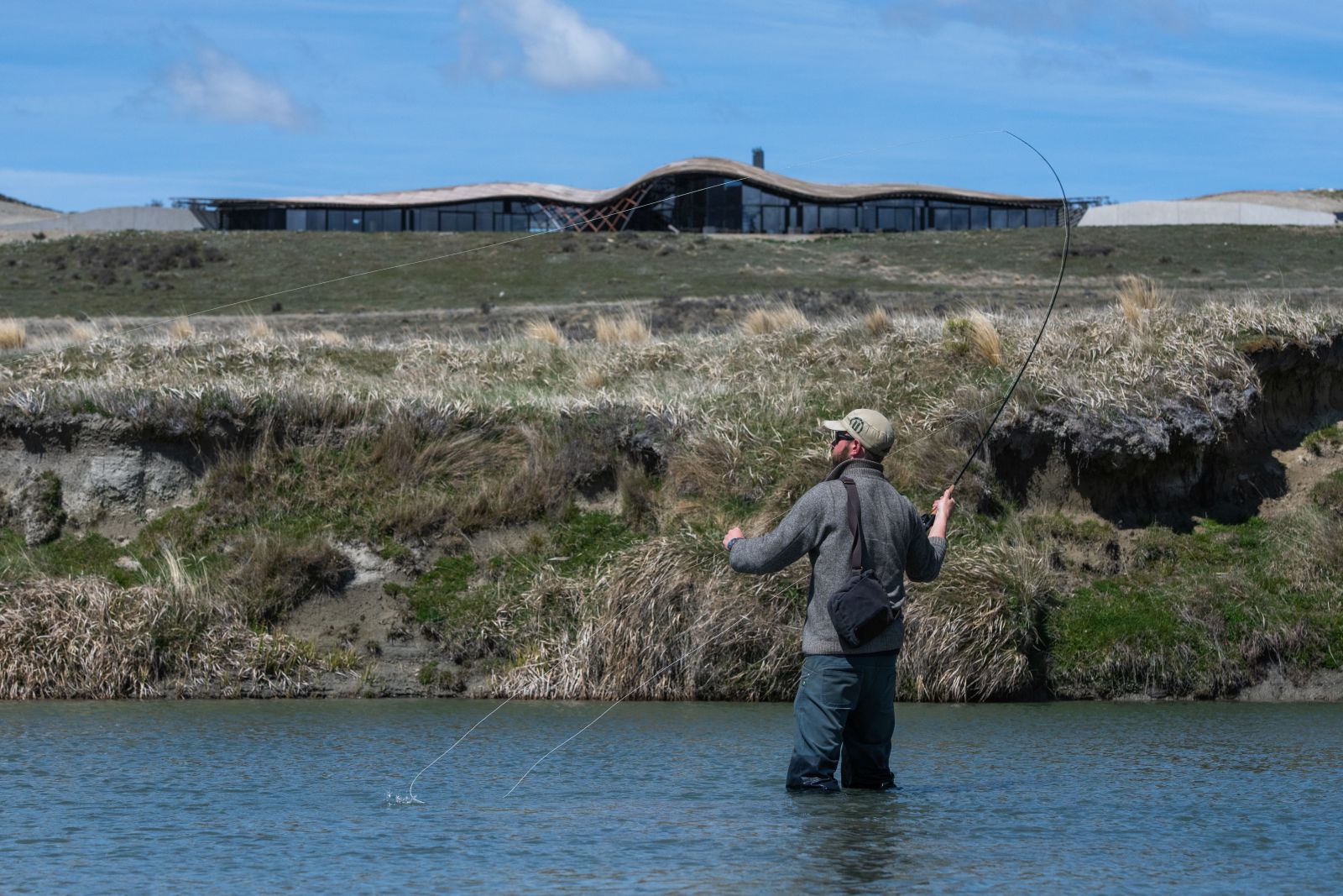 A man standing knee-high in the Ahuriri River fly fishing at The Lindis Lodge in New Zealand 