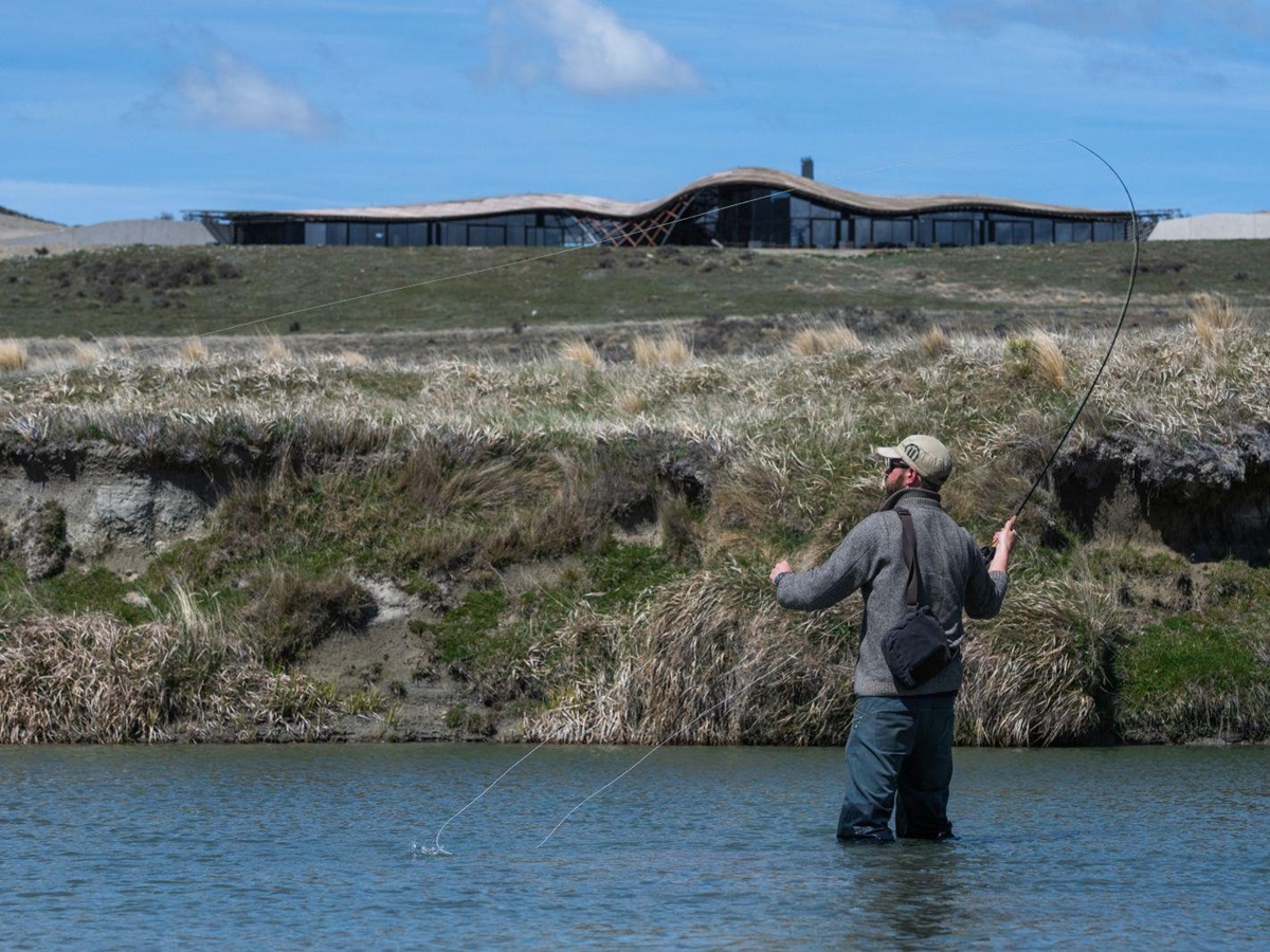 A man standing knee-high in the Ahuriri River fly fishing at The Lindis Lodge in New Zealand