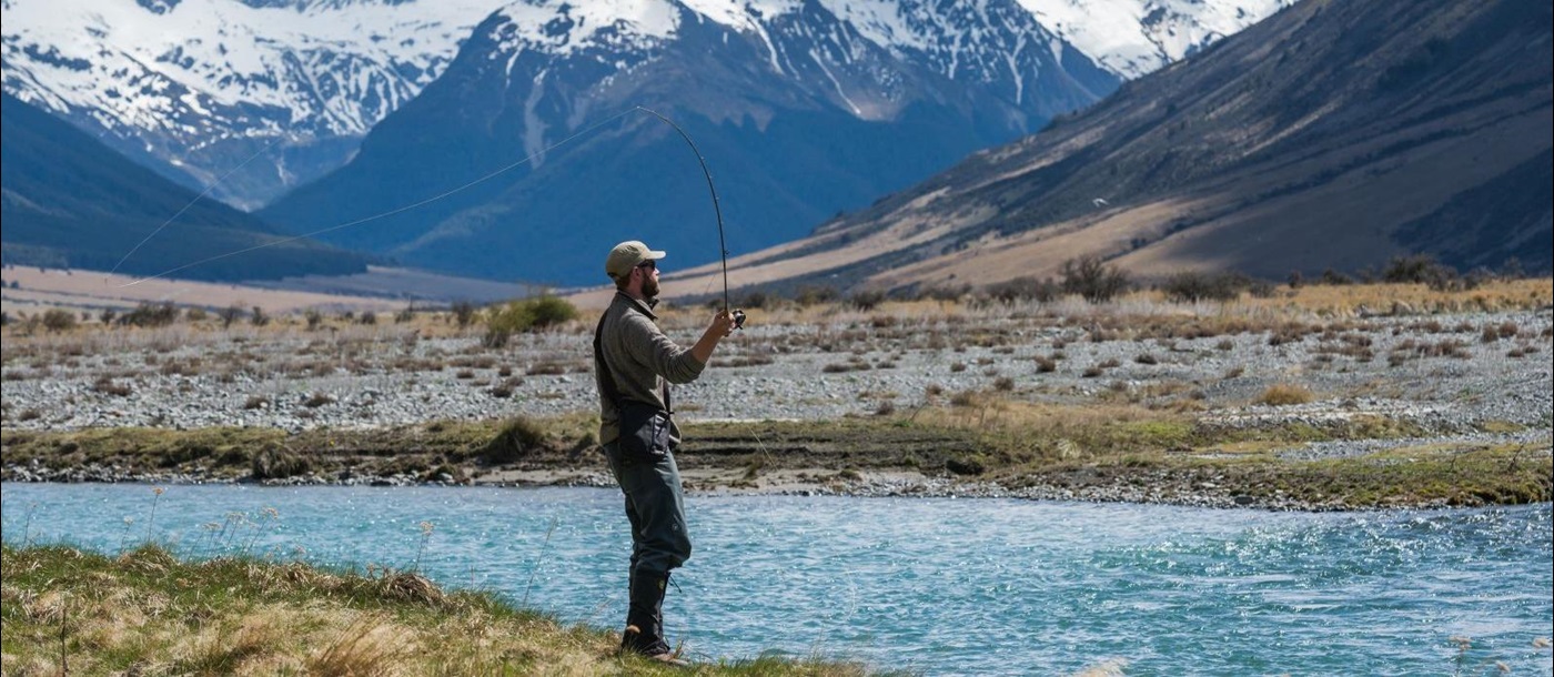 A man fly fishing on the edge of the Ahuriri River at The Lindis Lodge in New Zealand