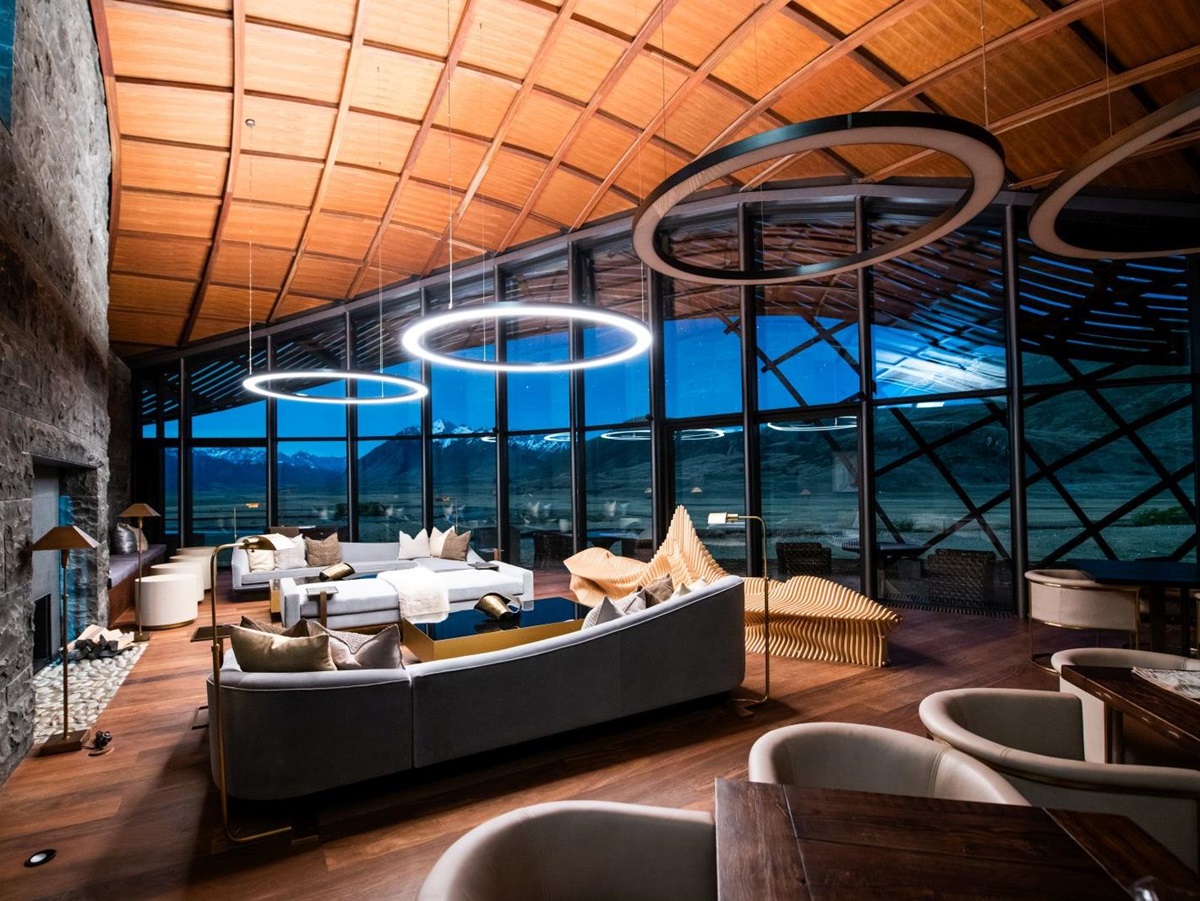 The interior of The Lindis Lodge in New Zealand with floor to ceiling windows looking out on the mountains