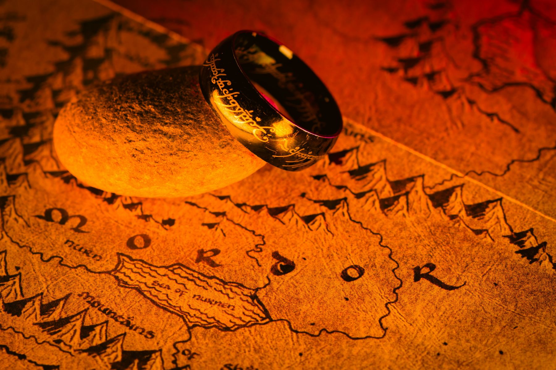 Detail shot of The One Ring against a map of Middle-Earth