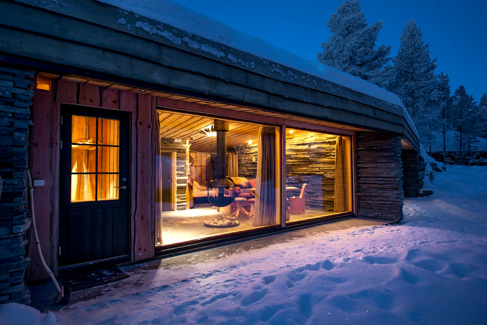 Facade of a guest cabin at night at Engholm Husky Design Lodge in Norway