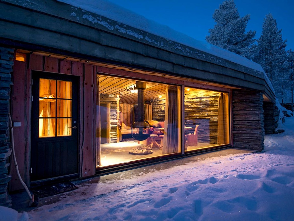 Facade of a guest cabin at night at Engholm Husky Design Lodge in Norway