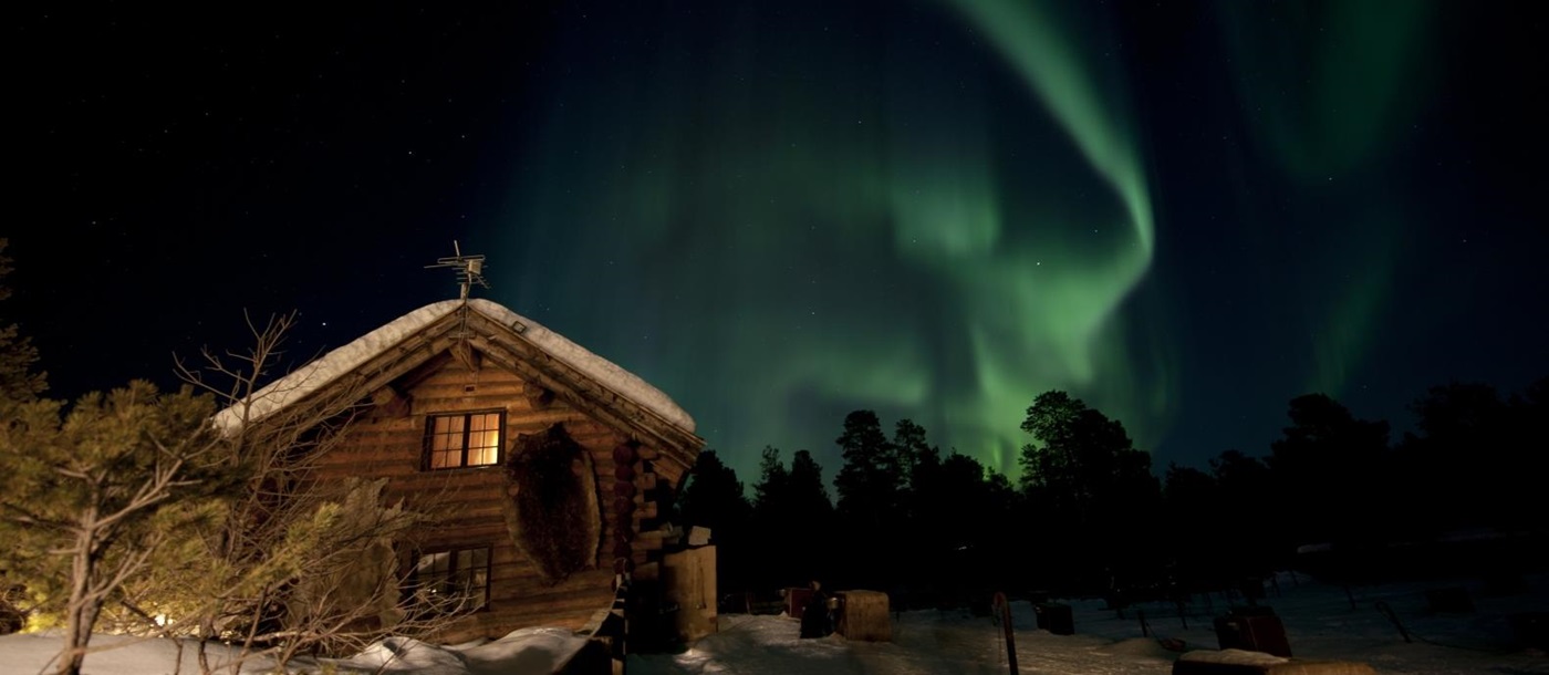 Northern lights above lodge at Engholm Husky Design Lodge in Norway