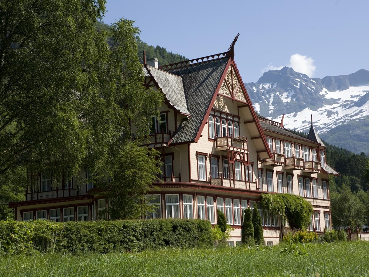 Exterior view of Hotel Union Oye with mountains in backdrop in Norway