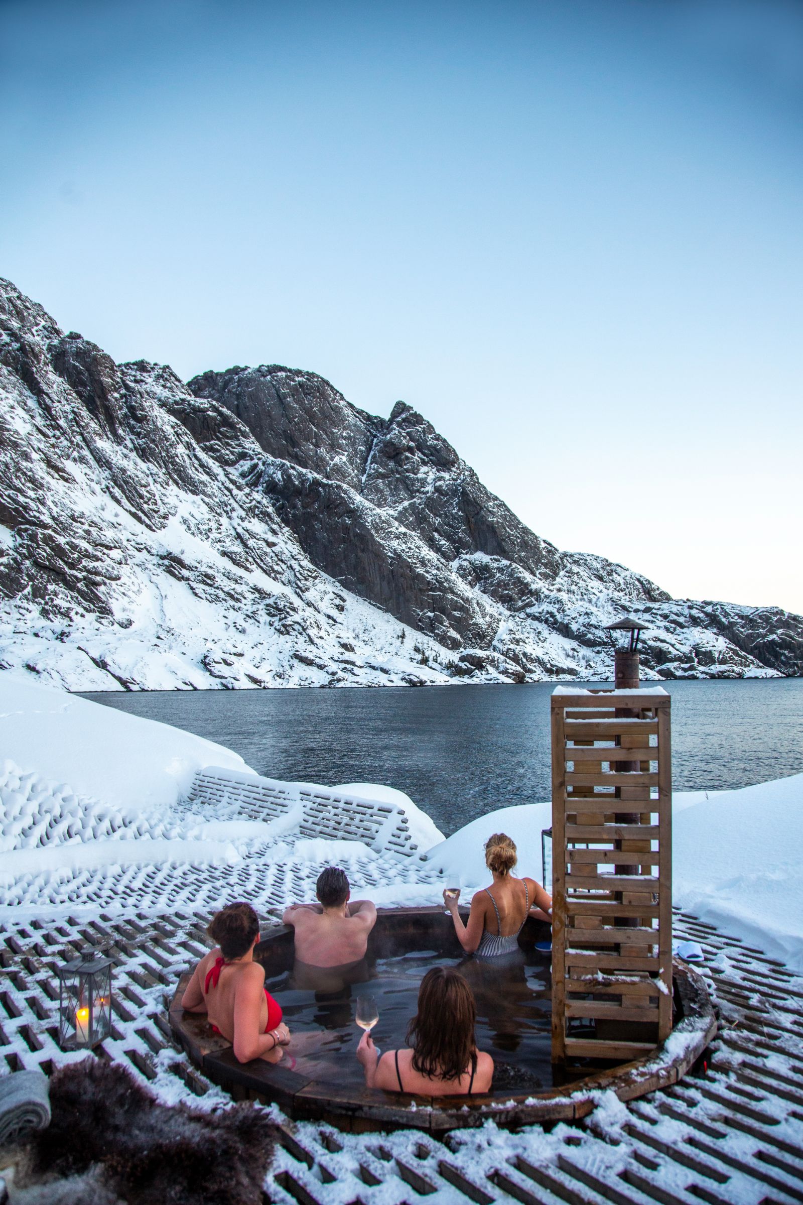 Guests of Nusfjord Arctic Resort in an open air hot tub