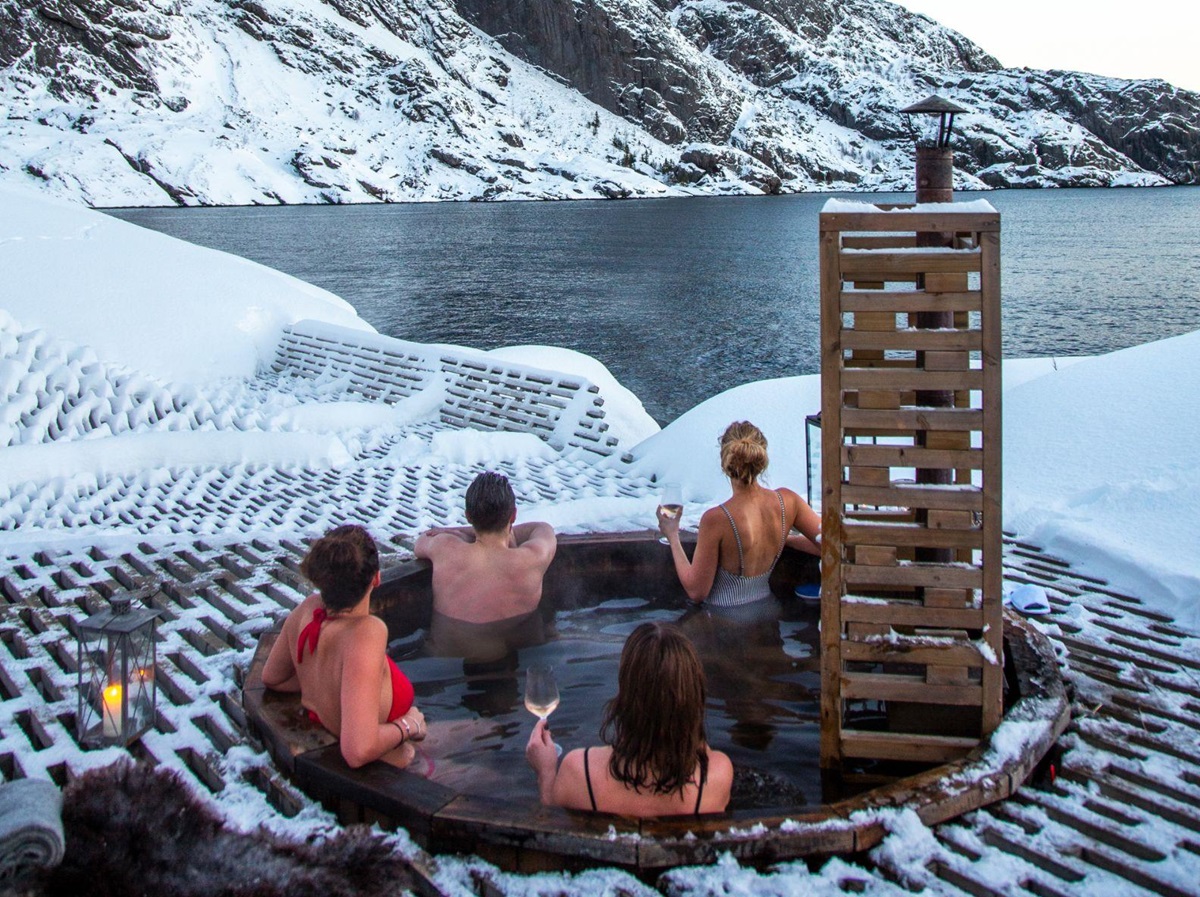 Guests of Nusfjord Arctic Resort in an open air hot tub