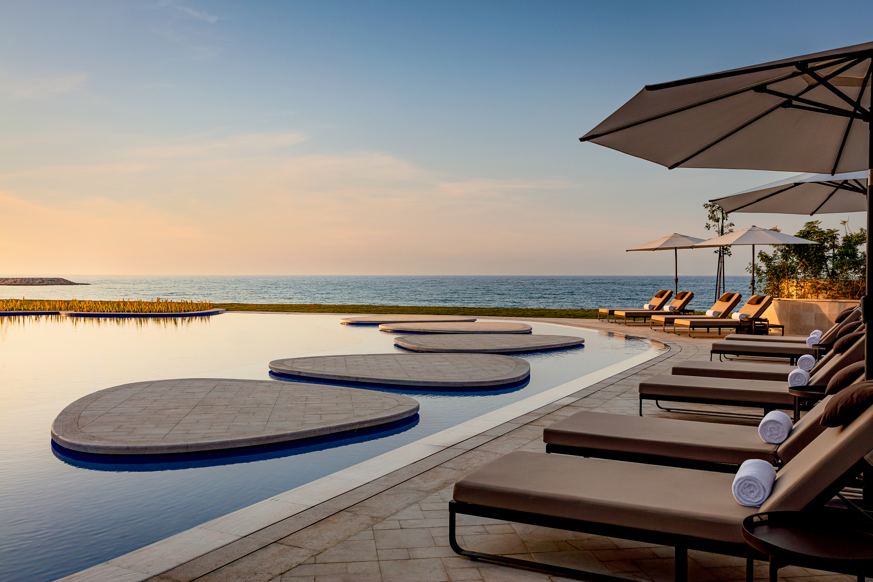 Swimming pool and loungers at St Regis Al Mouj Muscat Resort in Oman