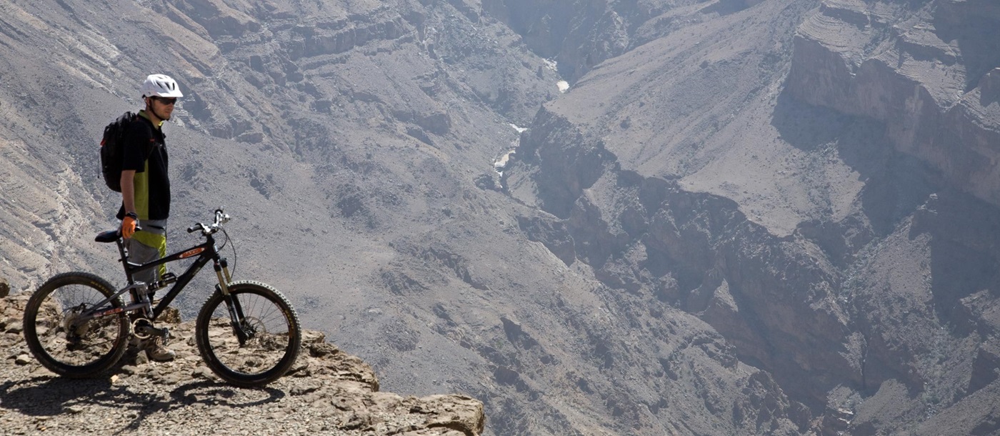 A biker overlooking a canyon near The View, Oman