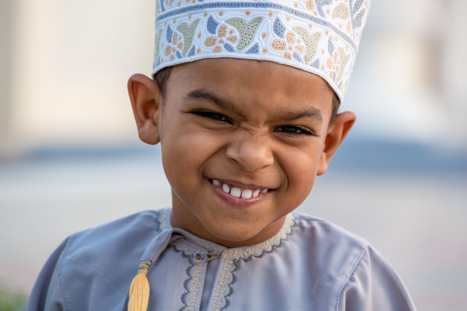 A smiling child in traditional dress in Oman
