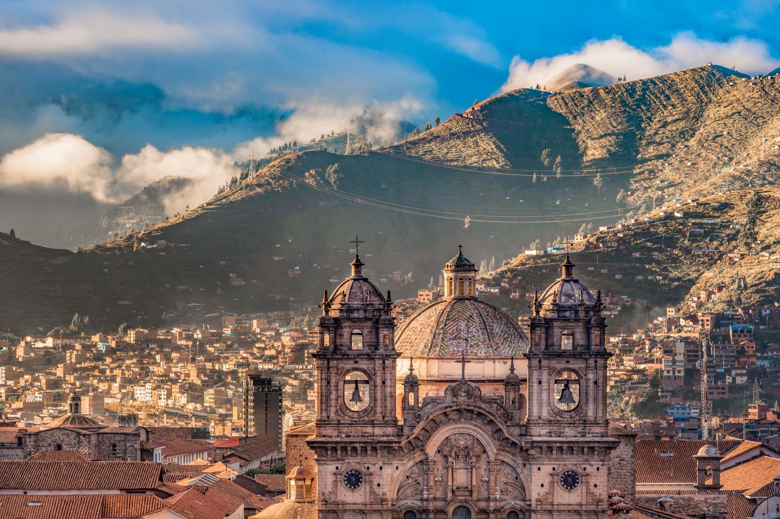 Cusco cathedral and city rooftops with the backdrop of the Andes in Peru
