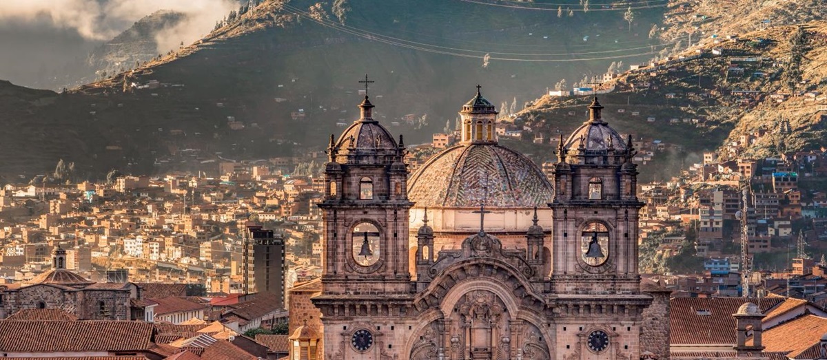 Cusco cathedral and city rooftops with the backdrop of the Andes in Peru
