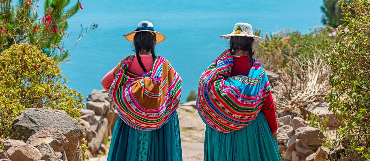 Ladies in traditional dress walking along a path in Taquile island, Peru