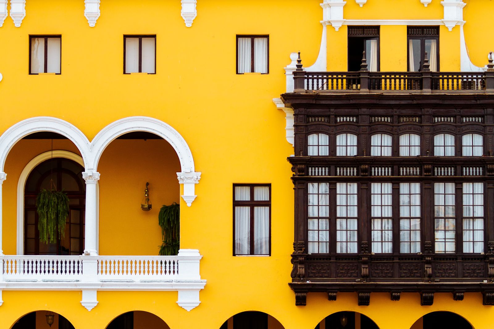 Traditional wooden balcony and the bright yellow buildings of Lima's municipality buildings in Peru