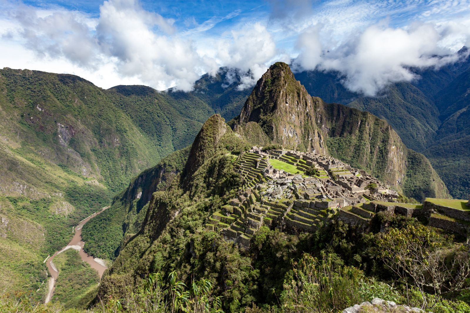 Aerial view of the Machu Picchu citadel, mountains and river valley below in Peru