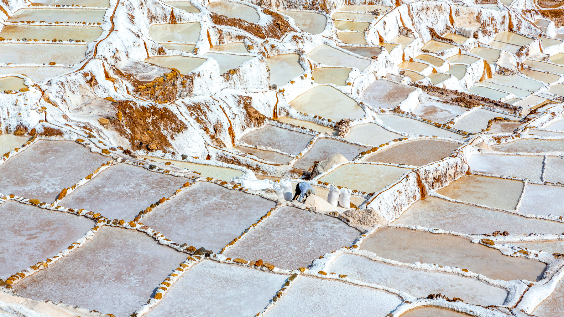 A man working the Maras salt mines in Peru