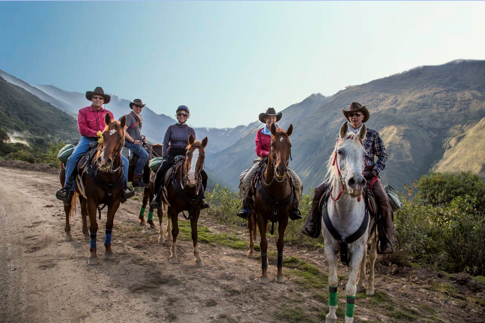 Five riders looking into the camera with mountains behind them