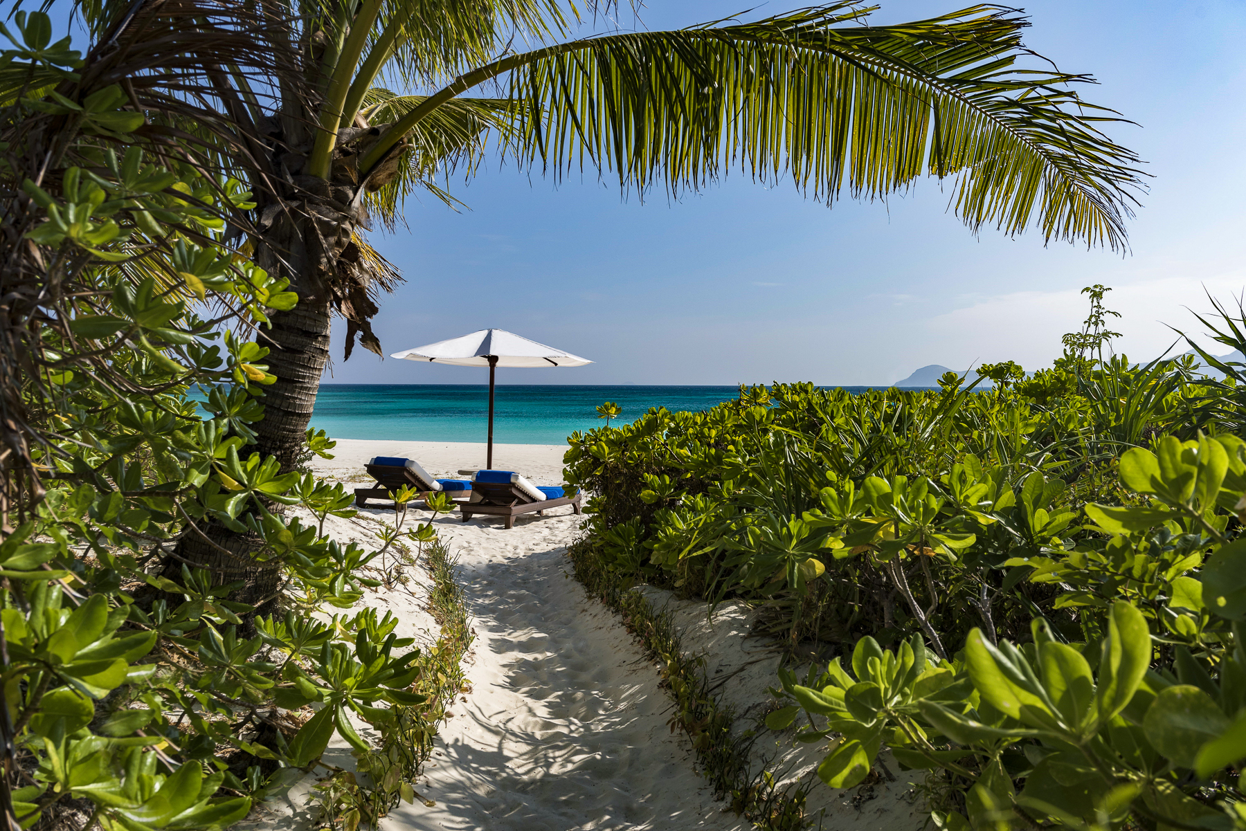 Beach loungers at Amanpulo luxury beach resort in the Philippines