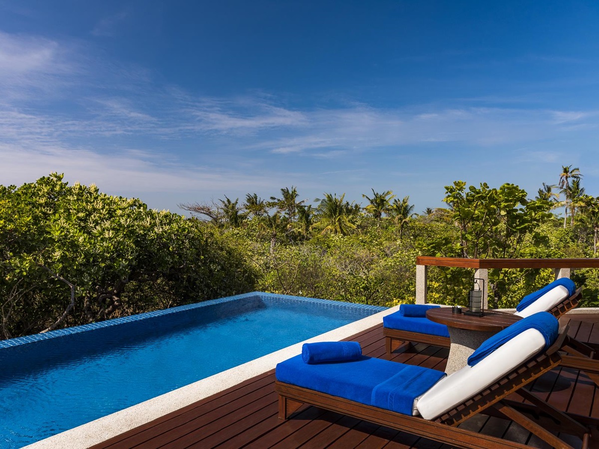 Loungers by the pool at Amanpulo luxury beach resort in the Philippines
