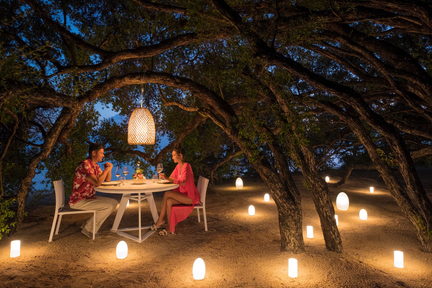 Couple enjoying a candlelit dinner under a tree at Banwa Private Island Philippines