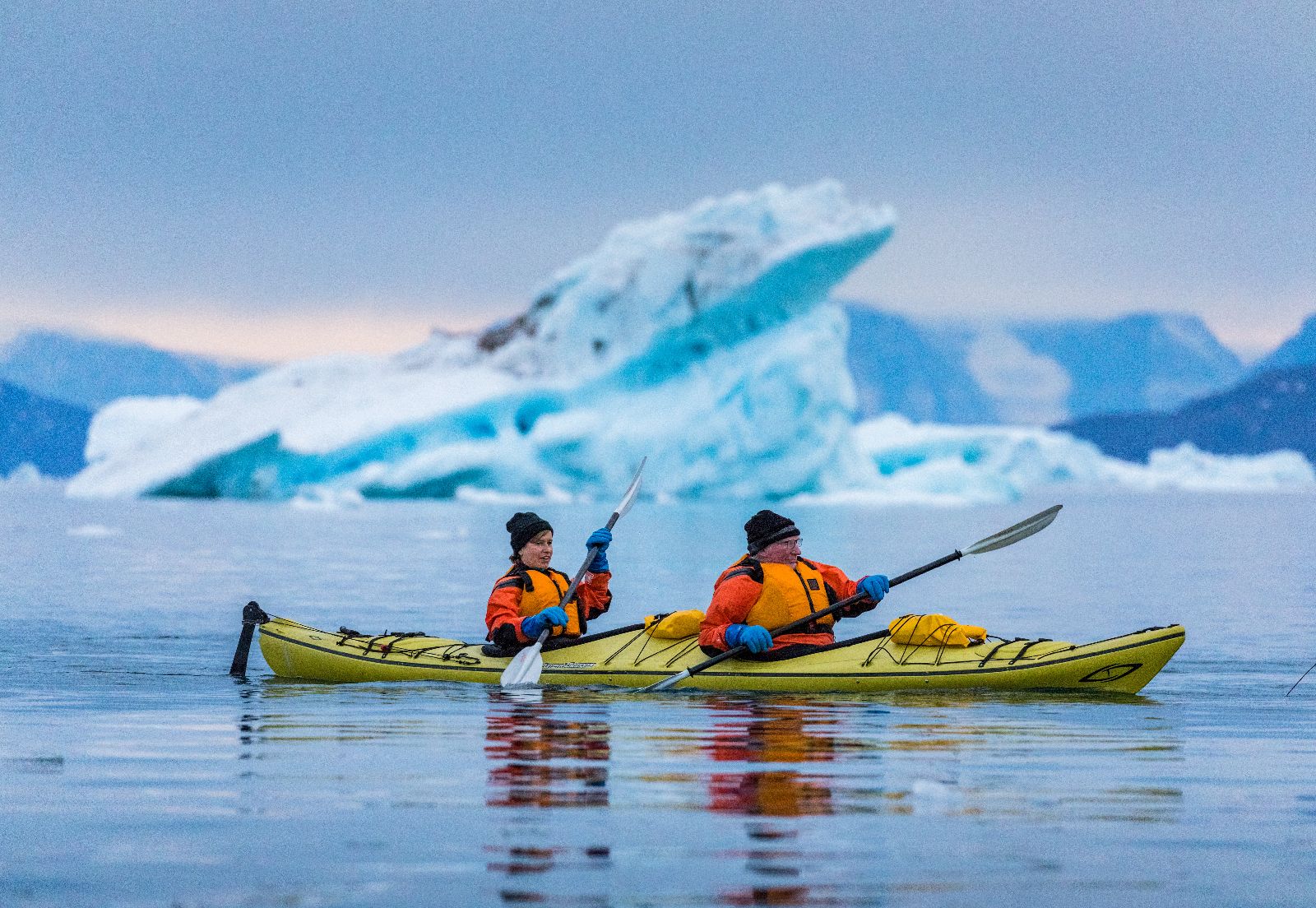 Guests of the Ultramarine kayaking past icebergs in Antarctica