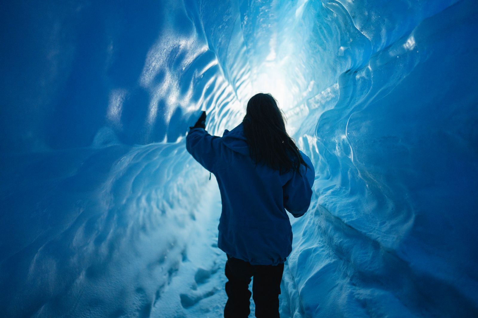 A woman exploring an ice tunnel in Antarctica near Whichaway camp by White Desert