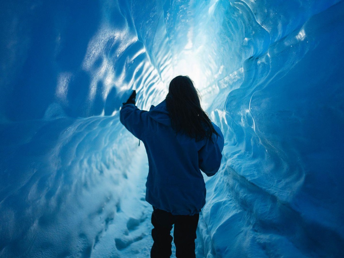A woman exploring an ice tunnel in Antarctica near Whichaway camp by White Desert