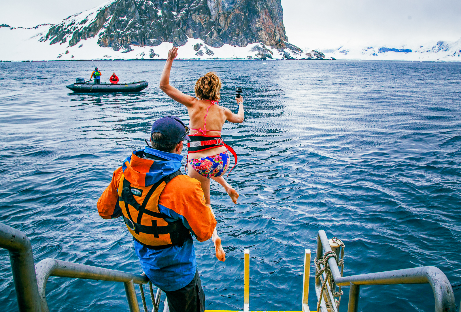 A woman taking the polar plunge from Quark's Ultramarine cruise ship