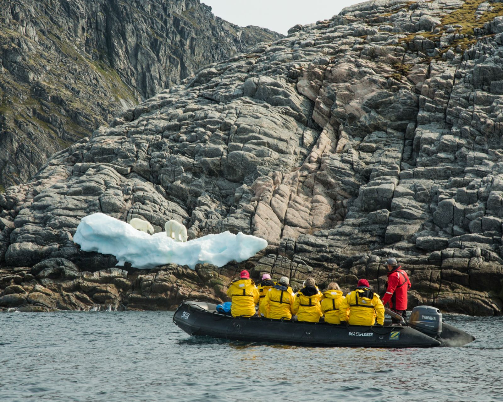 Passengers on Zodiac cruise around the coast of Monumental Island in Arctic Canada