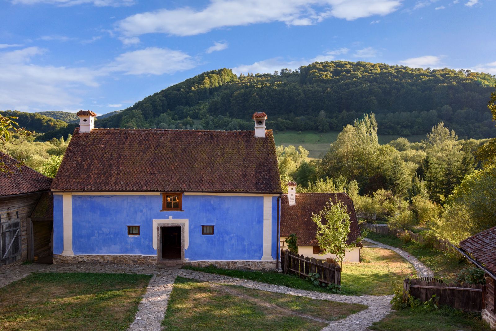 Blue cottage with backdrop of hills in Transylvania, Romania
