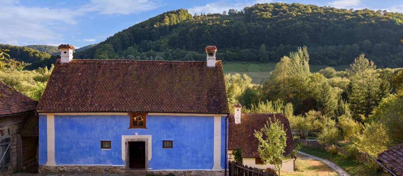 Blue cottage with backdrop of hills in Transylvania, Romania