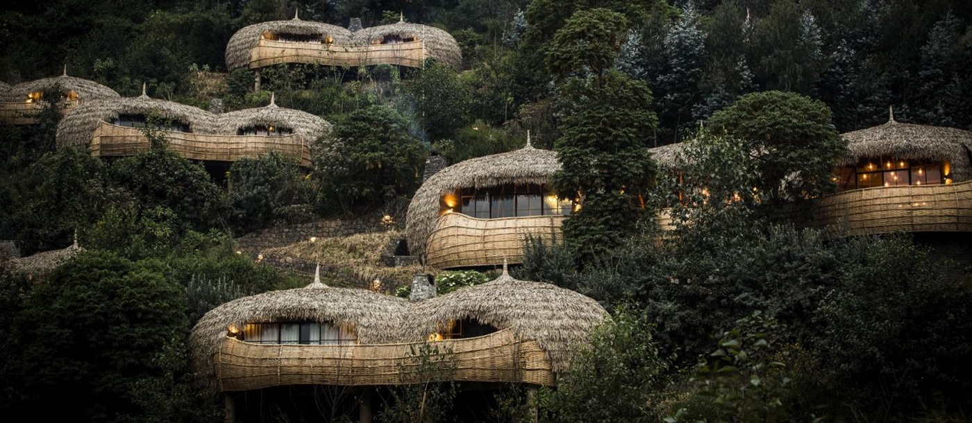 A view of the exterior of thatched bamboo villas set in the hillside at Bisate Lodge in Rwanda