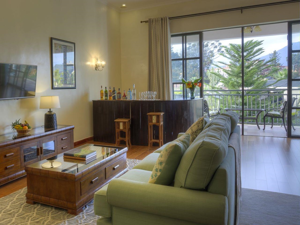 The living area with an outside balcony in a bedroom suite at The Bishops House hotel in Rwanda
