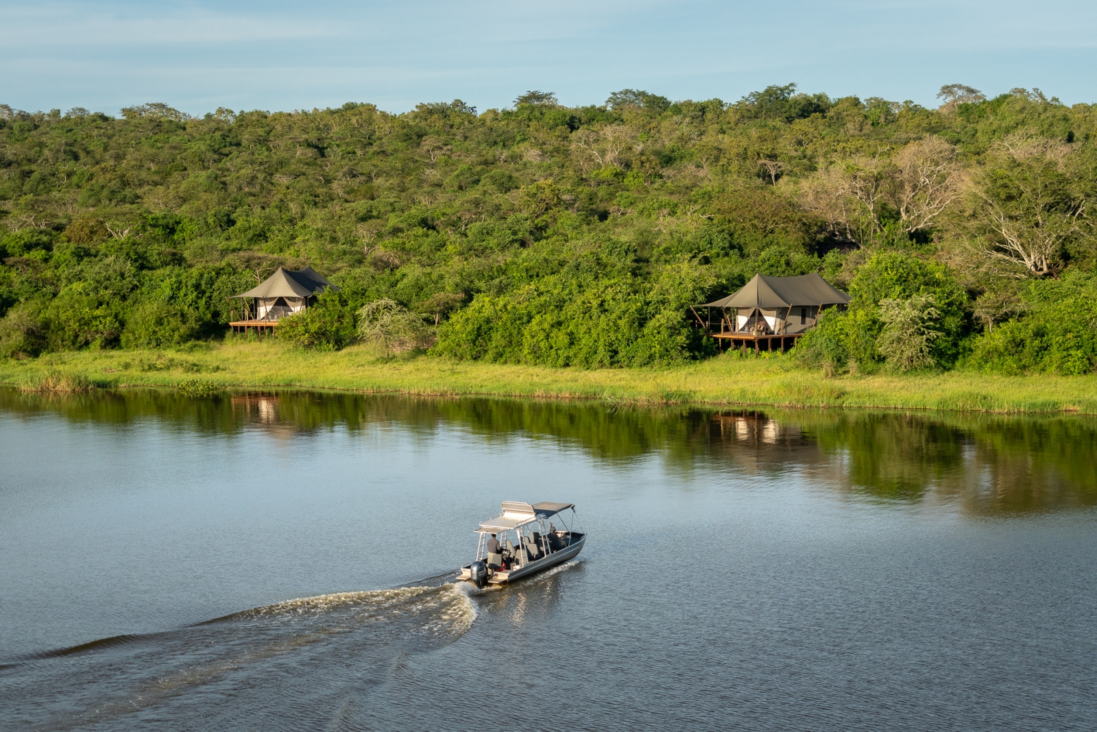 Speedboat on the lakes in front of two tents at Magashi Camp