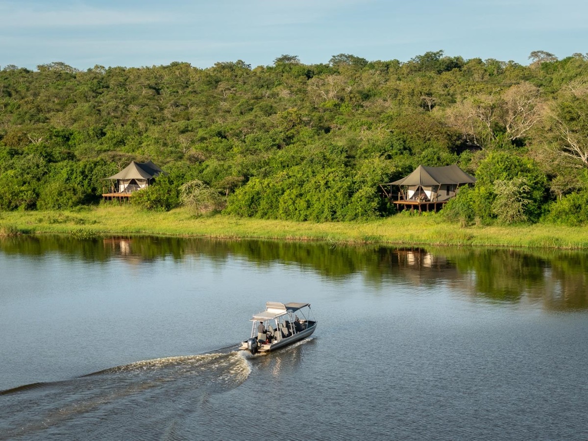 Speedboat on the lakes in front of two tents at Magashi Camp