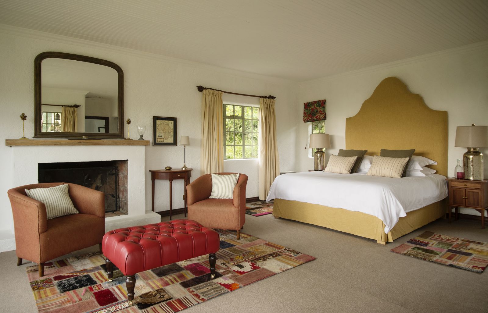 A double bedroom suite with a fireplace, chairs and table at Sabyinyo Silverback Lodge in Rwanda