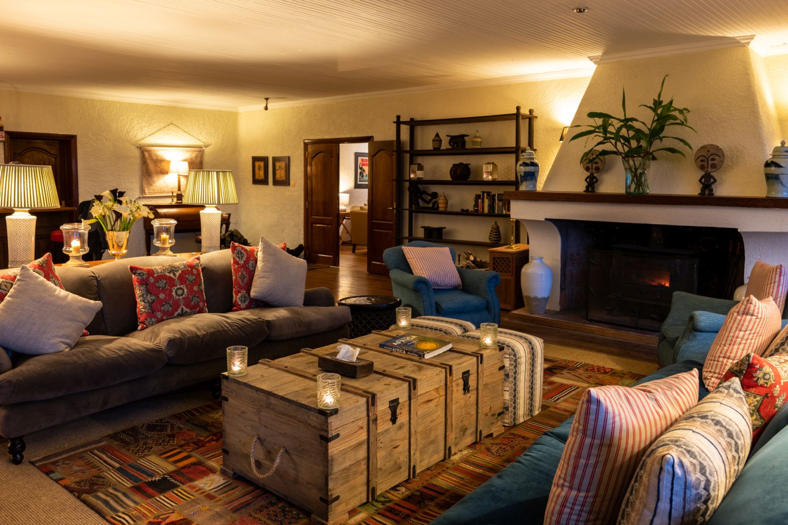 A living area with two sofas and a table in front of a fireplace at Sabyinyo Silverback Lodge in Rwanda