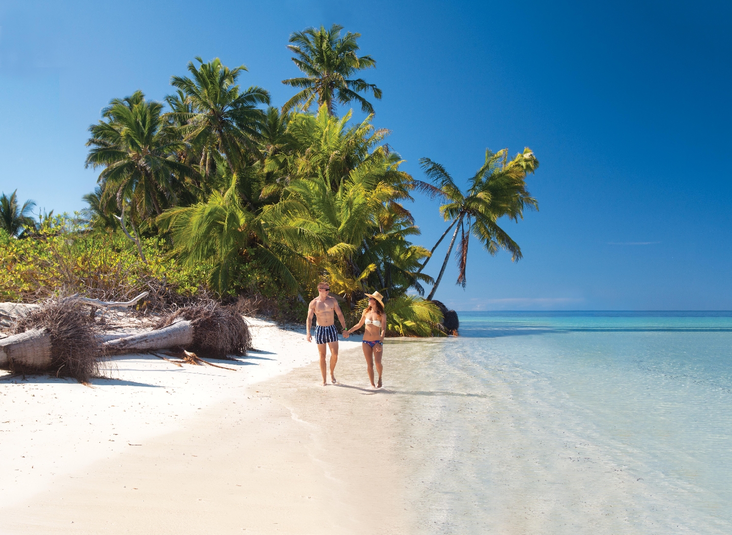 couple walking down the beach on alphone island, seychelles