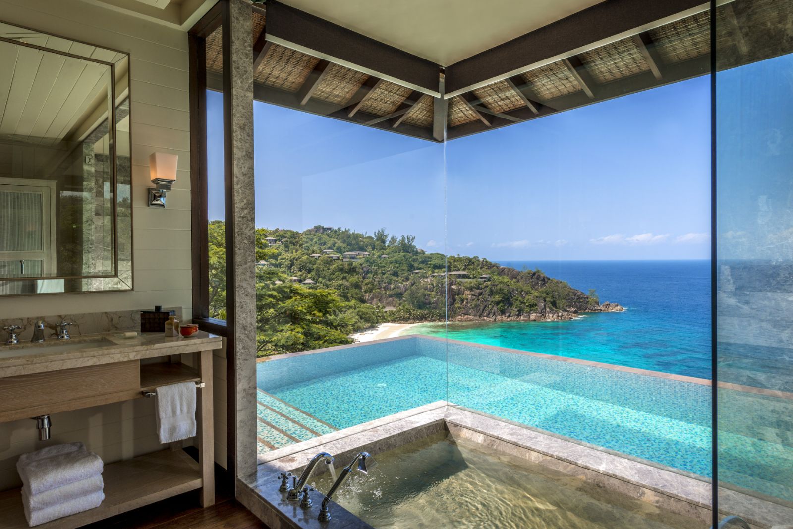 A guest suite bathroom overlooking the ocean at Four Seasons Seychelles