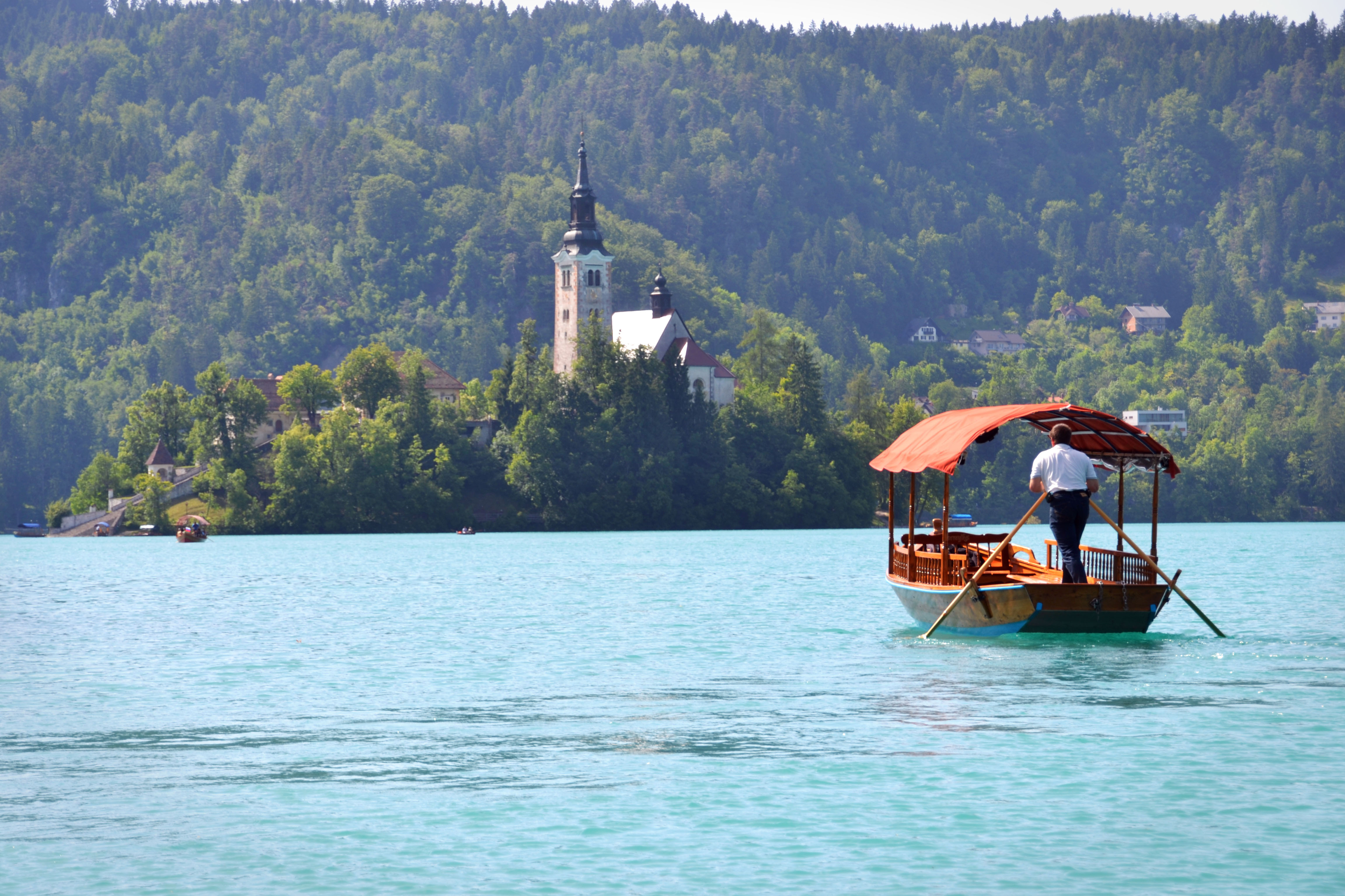 A pletna boat on Lake Bled surrounding Bled Castle