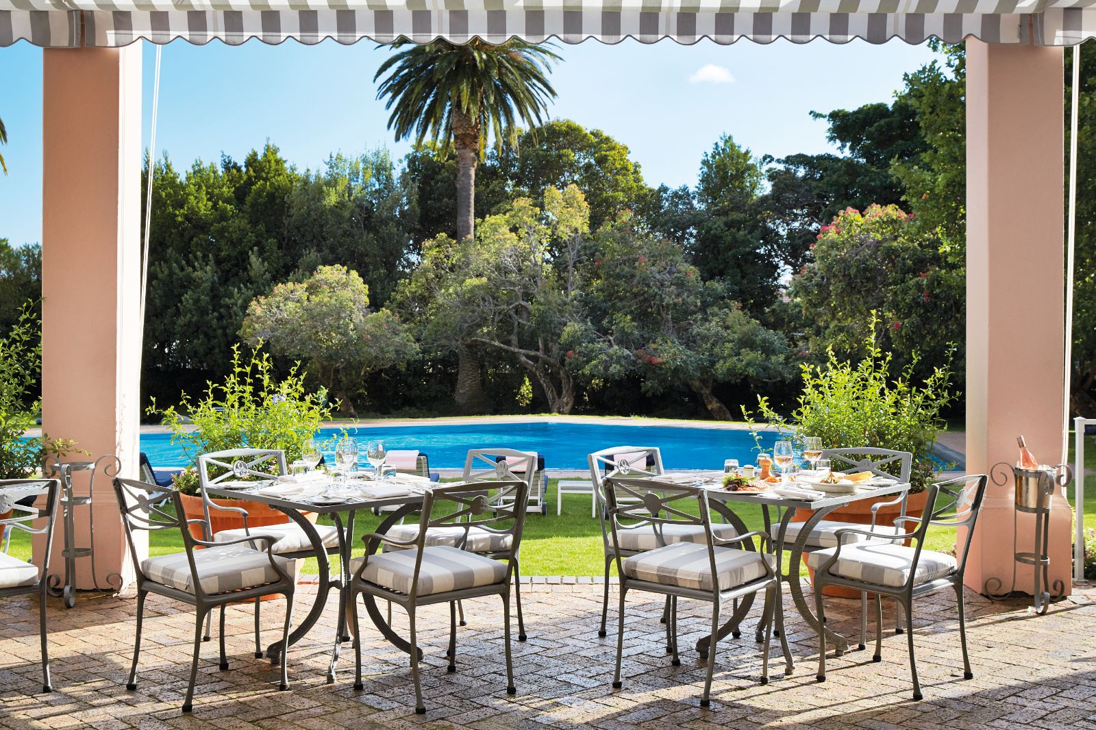 Poolside brunch tables set up during luxury hotel Belmond The Mount Nelson's weekly Sunday Jazz Brunch