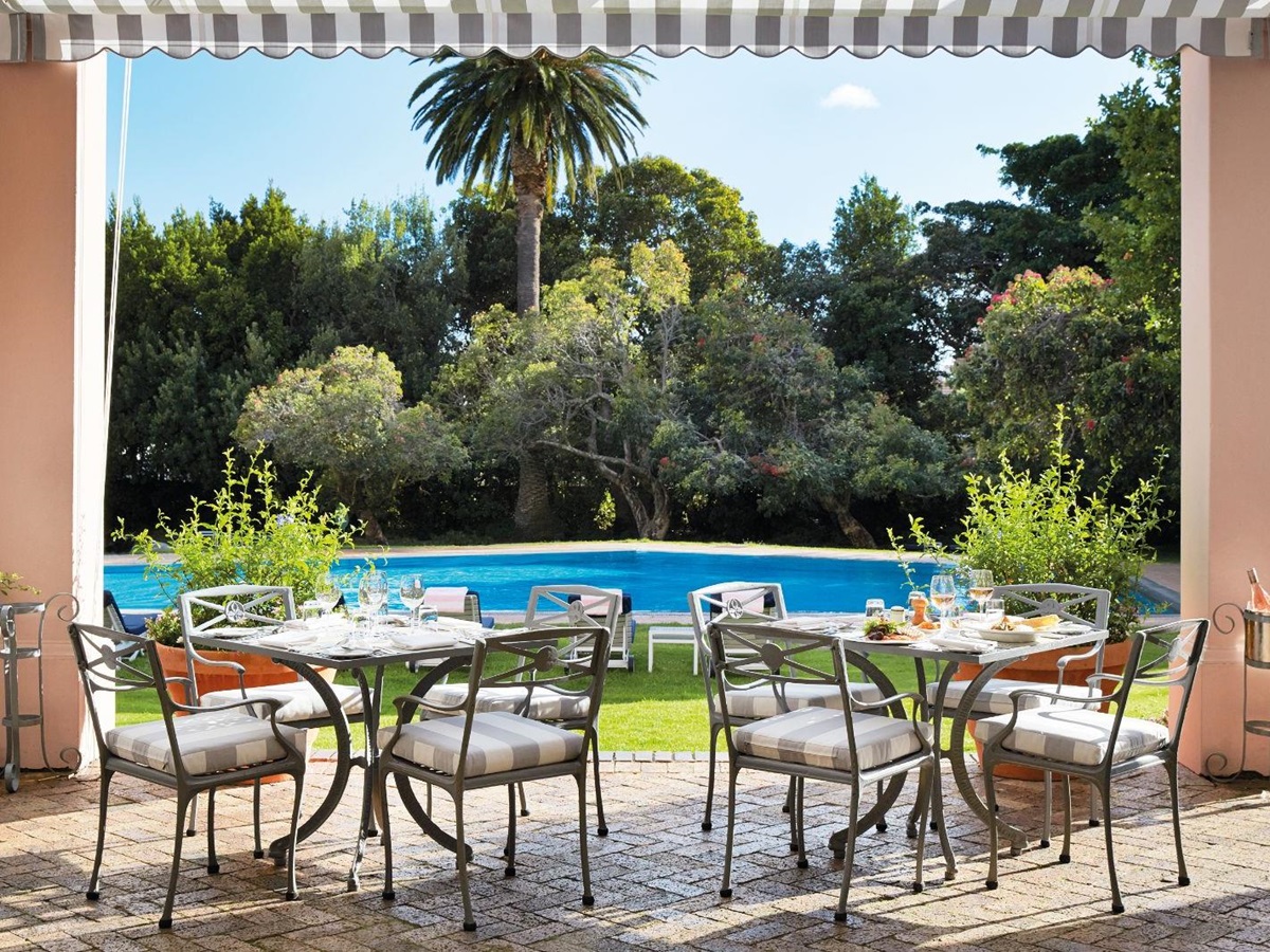 Poolside brunch tables set up during luxury hotel Belmond The Mount Nelson's weekly Sunday Jazz Brunch