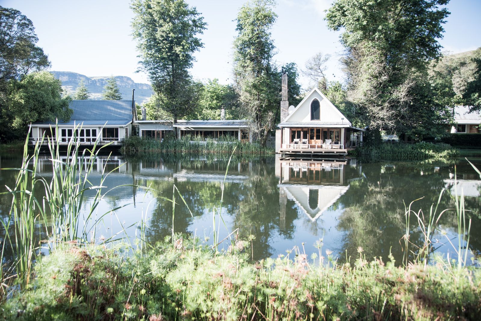 View of the lake and main lodge at Cleopatra Mountain Farmhouse in the Drakensberg mountains, South Africa